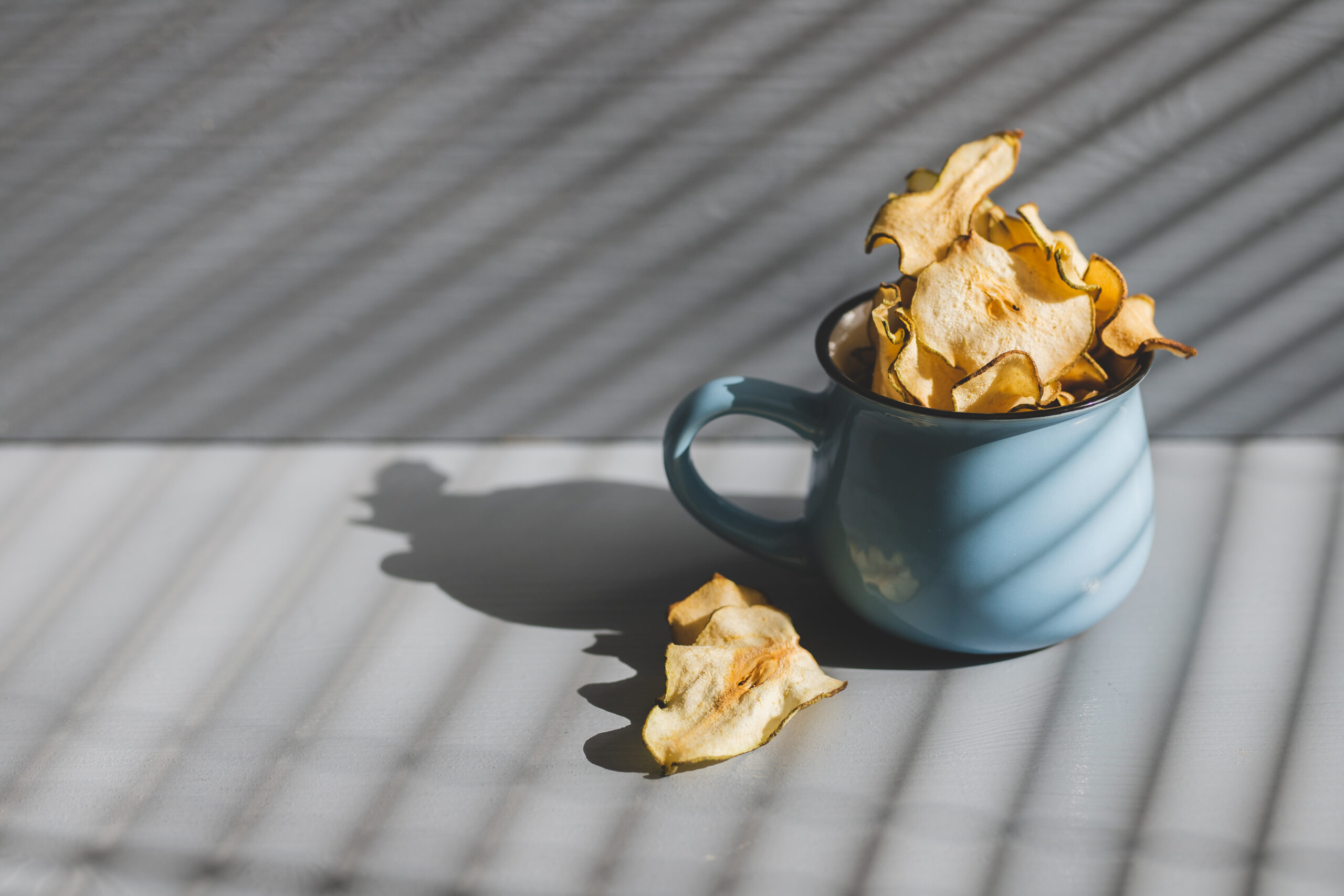 dried-pear-blue-cup-healthy-eating-still-life-with-light-through-blinds
